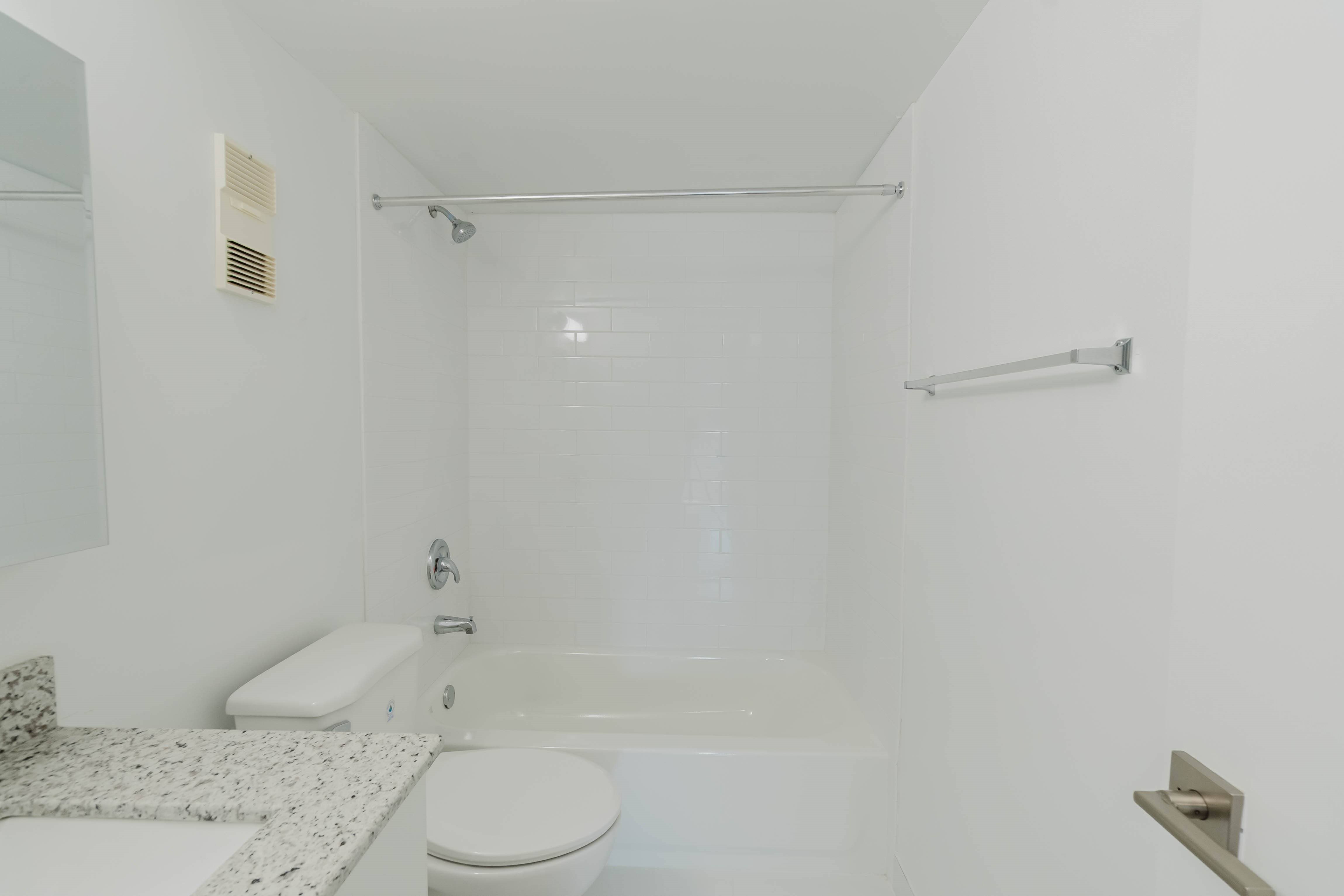 A white bathroom with a toilet, sink, and bathtub.